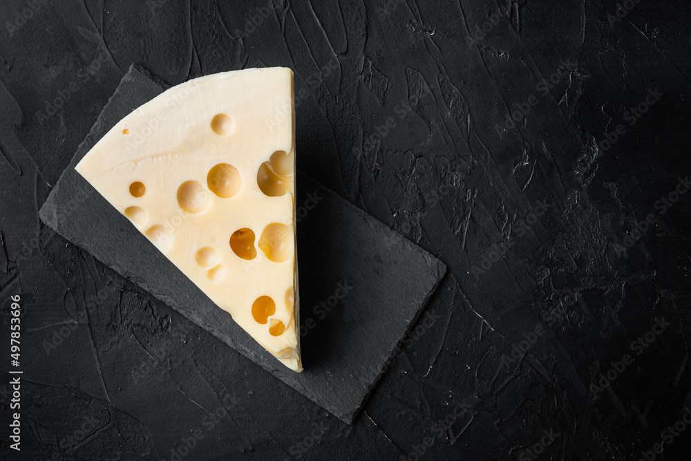 Maasdam cheese, on black stone background, top view flat lay, with copy space for text - obrazy, fototapety, plakaty 