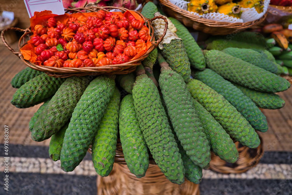 Monstera fruit or bananas, Monstera deliciosa, with a besaket pitangas on it on a market in Funchal, Madeira Islands, Portugal