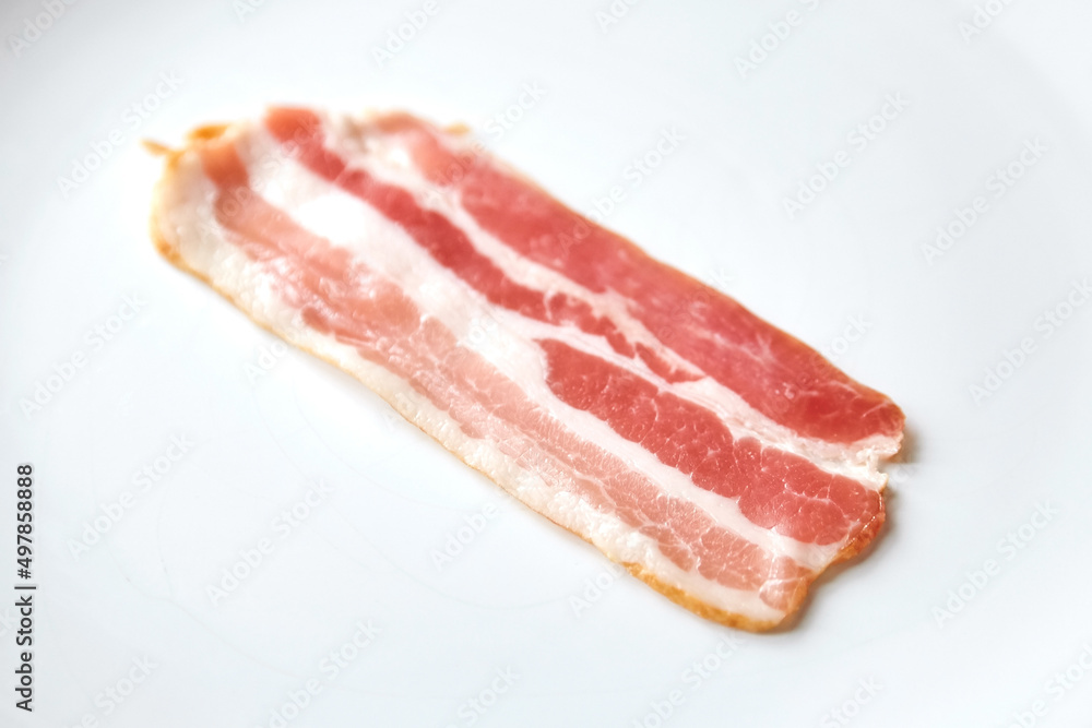 Bacon strip, raw smoked pork meat slice isolated on white Bacon strip, raw smoked pork meat slice isolated on white