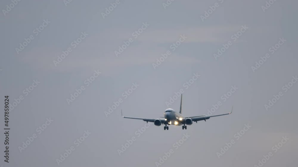 Commercial passenger plane has released landing gear and is ready to land, front view. Tourism and travel concept Commercial passenger plane has released landing gear and is ready to land, front view. Tourism and travel concept