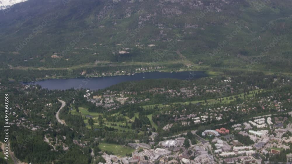 Whistler aerial tilt up from lake and town to mountains in summer Slowmo Whistler aerial tilt up from lake and town to mountains in summer Slowmo