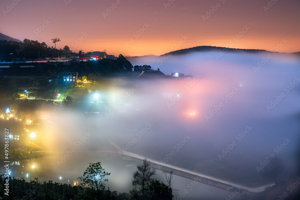 Night scene hillside a small town in fog shrouded by colorful houses and lights makes night in highlands of Da Lat, Vietnam so beautiful