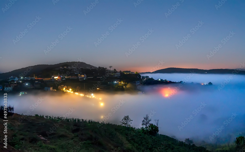 Night scene hillside a small town in fog shrouded by colorful houses and lights makes night in highlands of Da Lat, Vietnam so beautiful