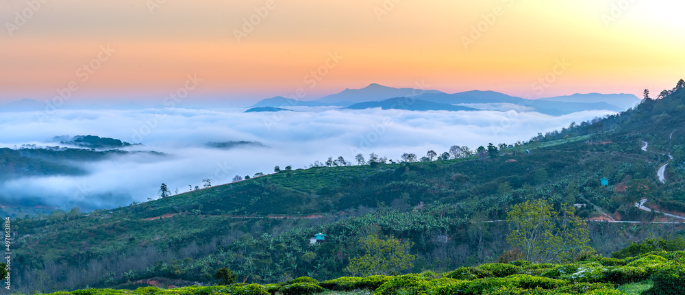New morning scene on top hill looking down with fog covering valley and peaceful sunrise sky background in Da Lat highland, Vietnam New morning scene on top hill looking down with fog covering valley and peaceful sunrise sky background in Da Lat highland, Vietnam