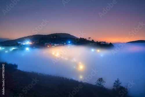 Night scene hillside a small town in fog shrouded by colorful houses and lights makes night in highlands of Da Lat  Vietnam so beautiful