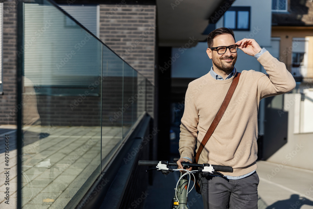 A fashionable man pushing a bike on the city street. A fashionable man pushing a bike on the city street.