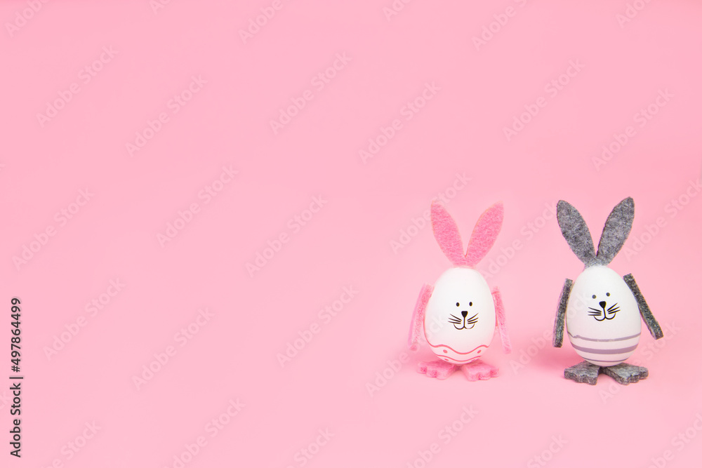 Easter. Easter bunnies, with their own hands on a pink background. Concept mocap and banner, congratulation, advertisement, invitation. High quality photo Easter. Easter bunnies, with their own hands on a pink background. Concept mocap and banner, congratulation, advertisement, invitation. High quality photo