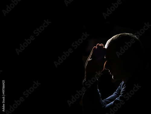 Foto Young man praying on dark background