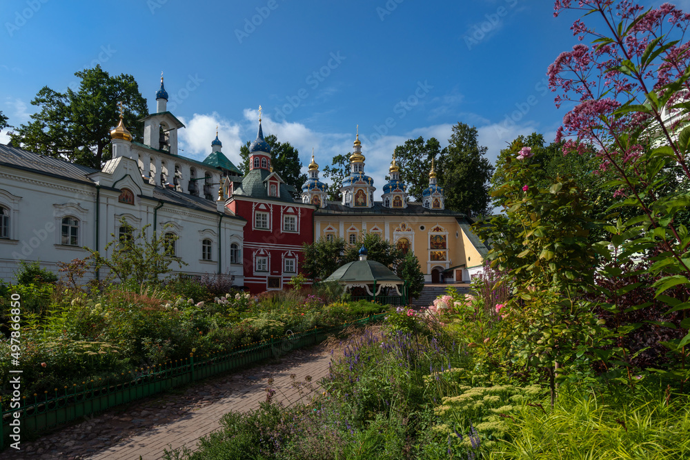 View of the Assumption Cave and Pokrovsky temples, the Sretensky Church and the sacristy of the Svyato-Uspenskiy Pskov-Pechersky Monastery on a sunny summer day, Pechory, Pskov region, Russia