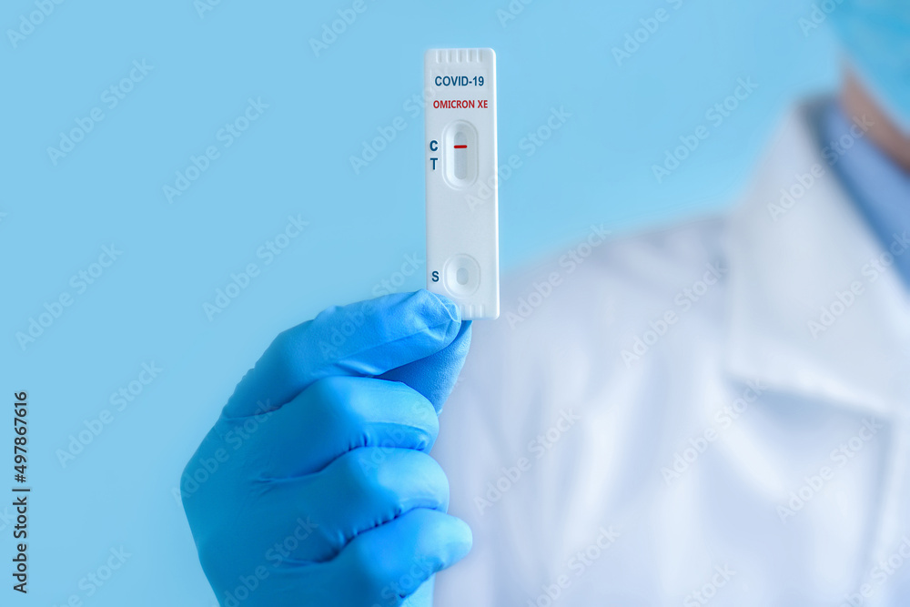 A doctor wearing a protective mask and gloves shows a rapid laboratory test for COVID-19 Omicron ?? variant strain to detect IgM and IgG antibodies to the new coronavirus. Negative result. A doctor wearing a protective mask and gloves shows a rapid laboratory test for COVID-19 Omicron ?? variant strain to detect IgM and IgG antibodies to the new coronavirus. Negative result.