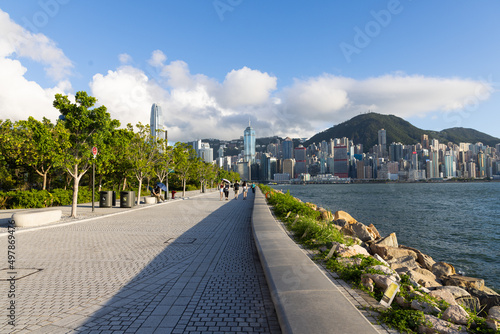 spacial walking area in West Kowloon Waterfront, Hong Kong. Buildings in Hong Kong Island, Victoria harbour and blue sky in background