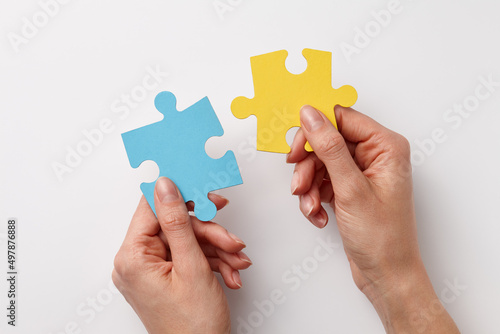 Ukrainian colors puzzle pieces in woman's hands