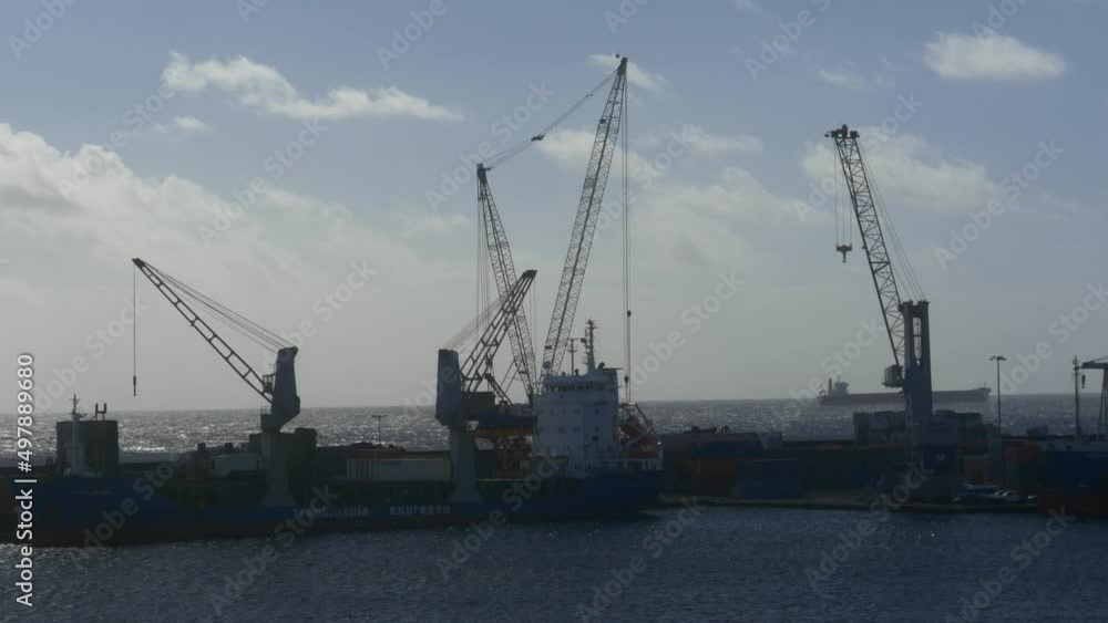 Cargo vessels using cranes to unload goods in Ponta Delgada, Azores Cargo vessels using cranes to unload goods in Ponta Delgada, Azores