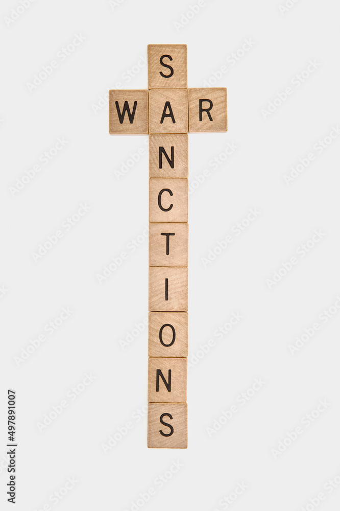 Cross made of words sanctions and war from wooden blocks. Conflict between Russia and Ukraine. Cross made of words sanctions and war from wooden blocks. Conflict between Russia and Ukraine.