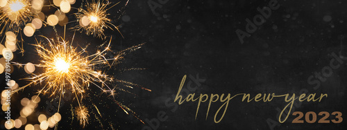 HAPPY NEW YEAR 2023, Silvester Party New year' Eve background banner panorama long, holiday greeting card - Sparklers and bokeh lights on dark night texture