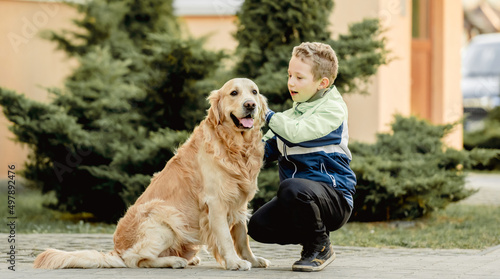 Preteen boy with golden retriever dog