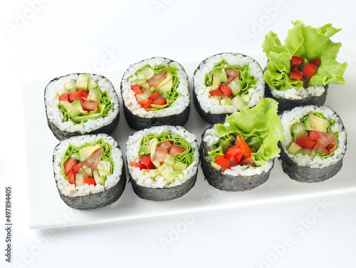 vegetable vegetarian sushi roll with vegetables in nori on a white plate isolated