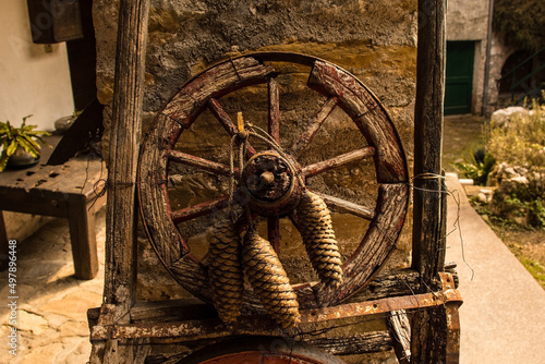 A rustic wooden wheel with pine tree cones in Poffabro, an historic medieval village in the Val Colvera valley in Pordenone province, Friuli-Venezia Giulia, north east Italy
 photo