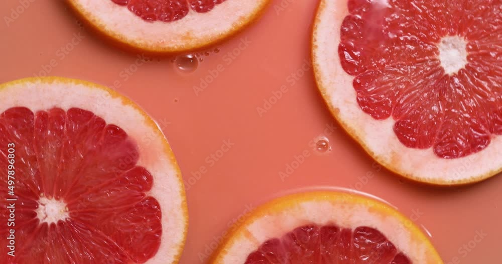 Top view rotation of fresh slice of grapefruits juice and gel serum , organic cosmetics, vitamin C, fresh citrus fruits, grapefruit extract Top view rotation of fresh slice of grapefruits juice and gel serum , organic cosmetics, vitamin C, fresh citrus fruits, grapefruit extract