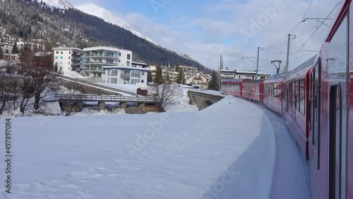 Arrival of the train at Davos Platz station. The red train travels along the snow-covered valleys of the Swiss Alps. photo