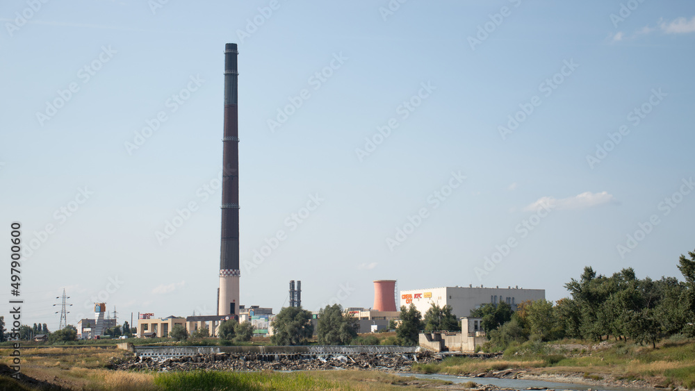 old industrial chimney overlooking suceava river and shopping centre.