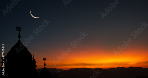 Leinwand Poster silhouette of a mosque at sunset with crescent moon on dusk sky in the evening r