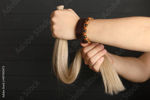 The male hand holds sections of hair for extension. photo