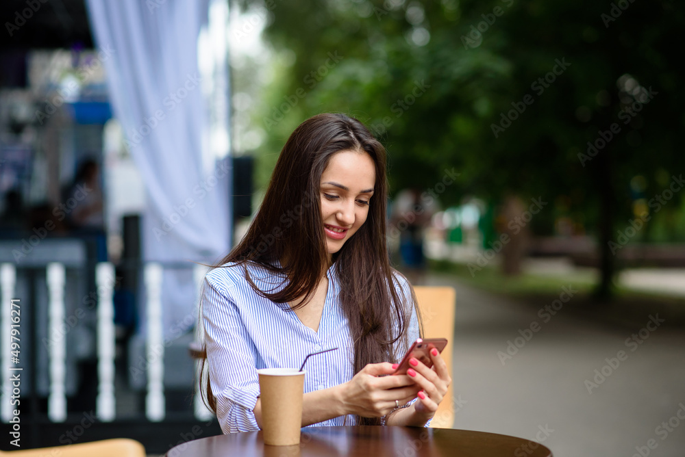 communication, technology and people concept - happy smiling young woman with coffee and smartphone on city street