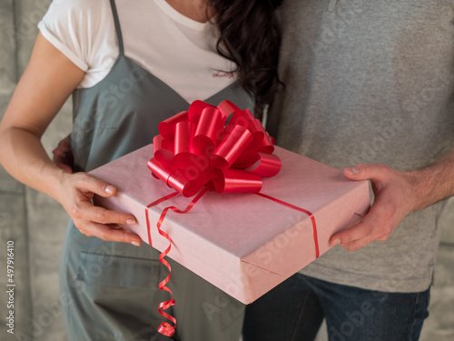 Man presents a girt box for woman. Close up view of celebrating couple photo