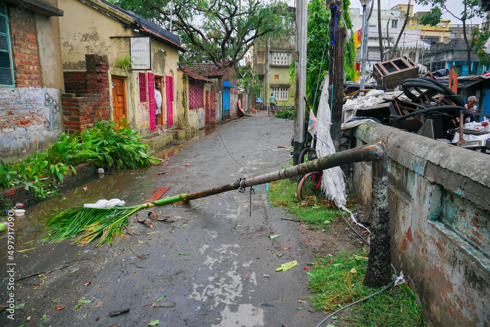 Howrah, West Bengal, India - 21st May 2020 : Super cyclone Amphan broke a roadside tree which fell and blocked road. The devastation has made many trees fall on ground. Howrah, West Bengal, India - 21st May 2020 : Super cyclone Amphan broke a roadside tree which fell and blocked road. The devastation has made many trees fall on ground.