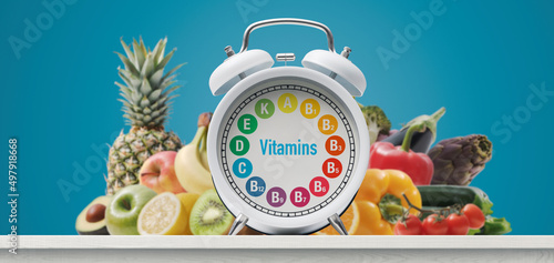 Foto Alarm clock with vitamins and fresh greens
