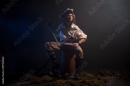 Pirate filibuster sea robber in suit with gun and saber. Concept photo