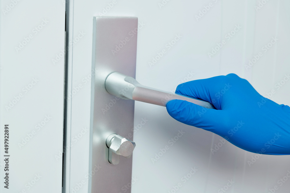 Naklejka premium Woman's hand open the door with glove