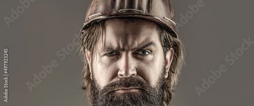 Builder in hard hat, foreman or repairman in the helmet. Building, industry - builder concept. Bearded man worker with beard in building helmet or hard hat. Man builders, industry