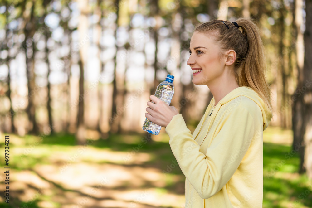 Sporty woman drinking water in the nature. Sporty woman drinking water in the nature.