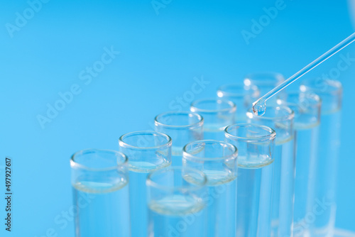 Liquid drop to test tube on blue background
