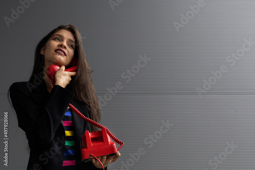 Young Latin American woman with a red headset and positive attitude, posing on camera. Youth and vintage technology concept