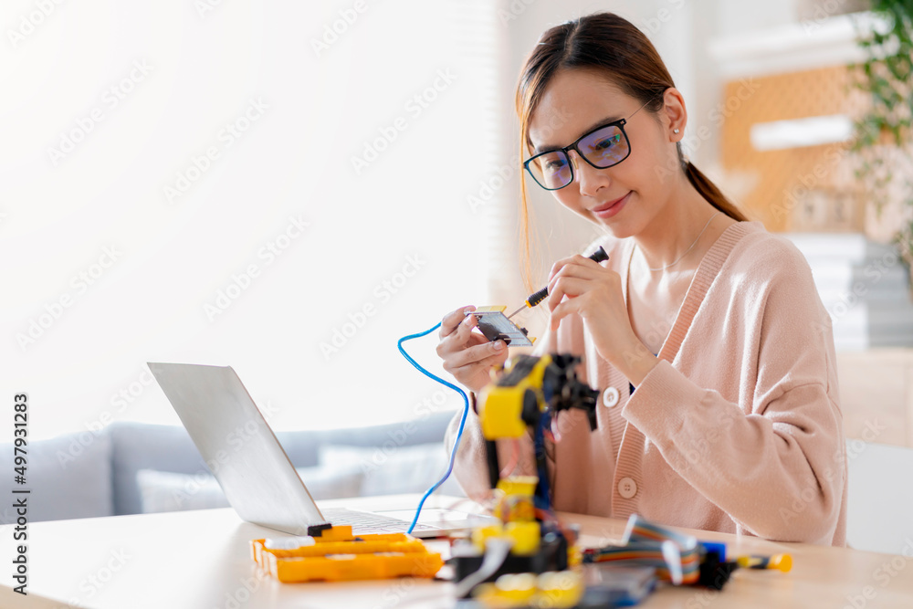 smart asian female programer learning robot arm ai coding electronic board cable in STEM, STEAM she try to testing her autonomous robotic arm with sensors via Arduino platform at home smart asian female programer learning robot arm ai coding electronic board cable in STEM, STEAM she try to testing her autonomous robotic arm with sensors via Arduino platform at home