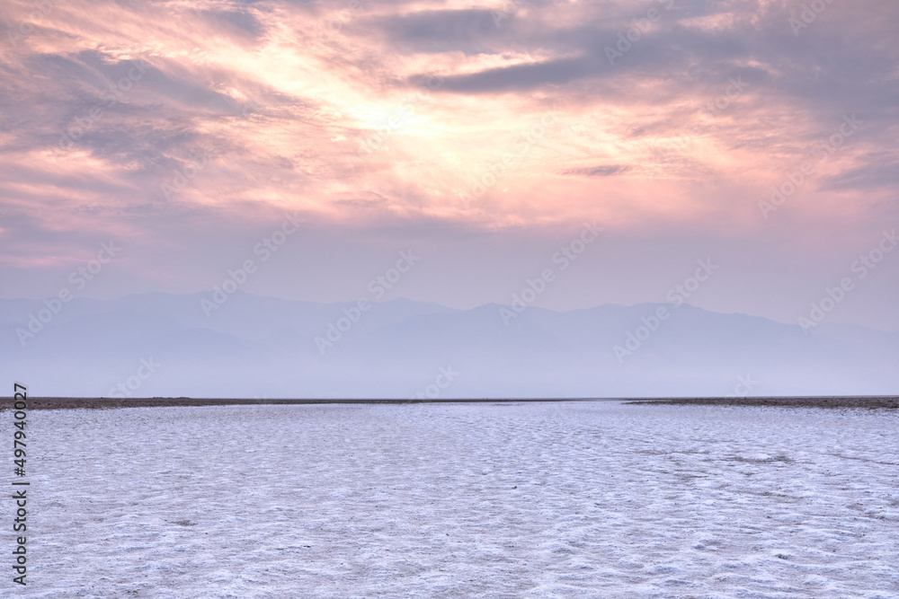 Salt flats in Death Valley at sunset. Mountains are hidden in haze