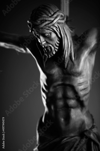 Religion theme - Jesus Christ. Cruciefied Jesus figure isolated on rustic dark background. © zolnierek