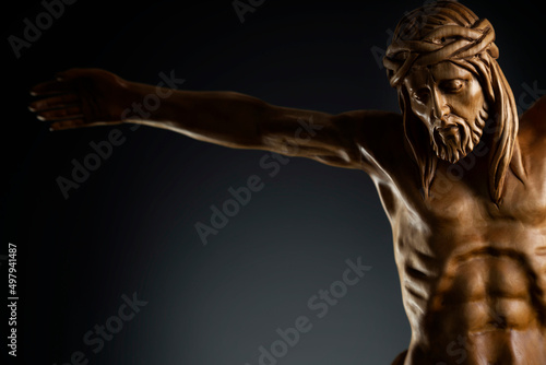 Religion theme - Jesus Christ. Cruciefied Jesus figure isolated on rustic dark background.