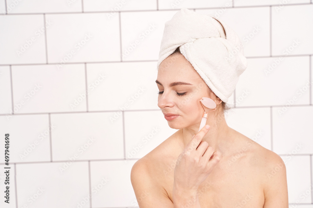 Young woman doing morning routine. Batroom maternity treatment. Health care concept. Female person. Pandemic concept. Pink guasha acupuncture face massage Young woman doing morning routine. Batroom maternity treatment. Health care concept. Female person. Pandemic concept. Pink guasha acupuncture face massage