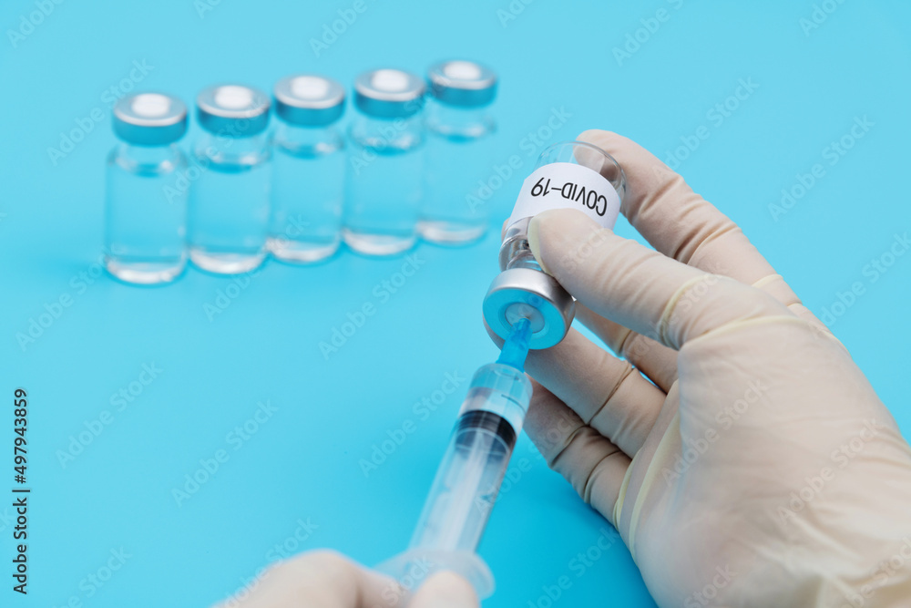 Hand holding syringe and Covid-19 vaccine Hand holding syringe and Covid-19 vaccine