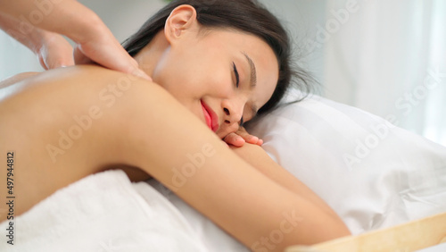 Close up masseur hands doing back massage with oil in the beauty spa. Woman lying down on the spa bed. Relaxing or revitalizing of muscle after work. Enjoying full body care. Healthy and spa concept