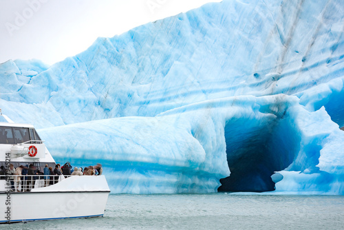 Escursione in barca  di un gruppo di turisti per ammirare un iceberg in Patagonia  photo