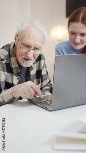 Woman volunteer helping elderly and sick man use video call