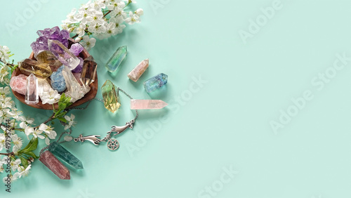 gemstones minerals, wiccan amulet and flowers on green background. Magic Crystal ritual, Esoteric spiritual practice for harmony, relax. Witchcraft. top view. copy space