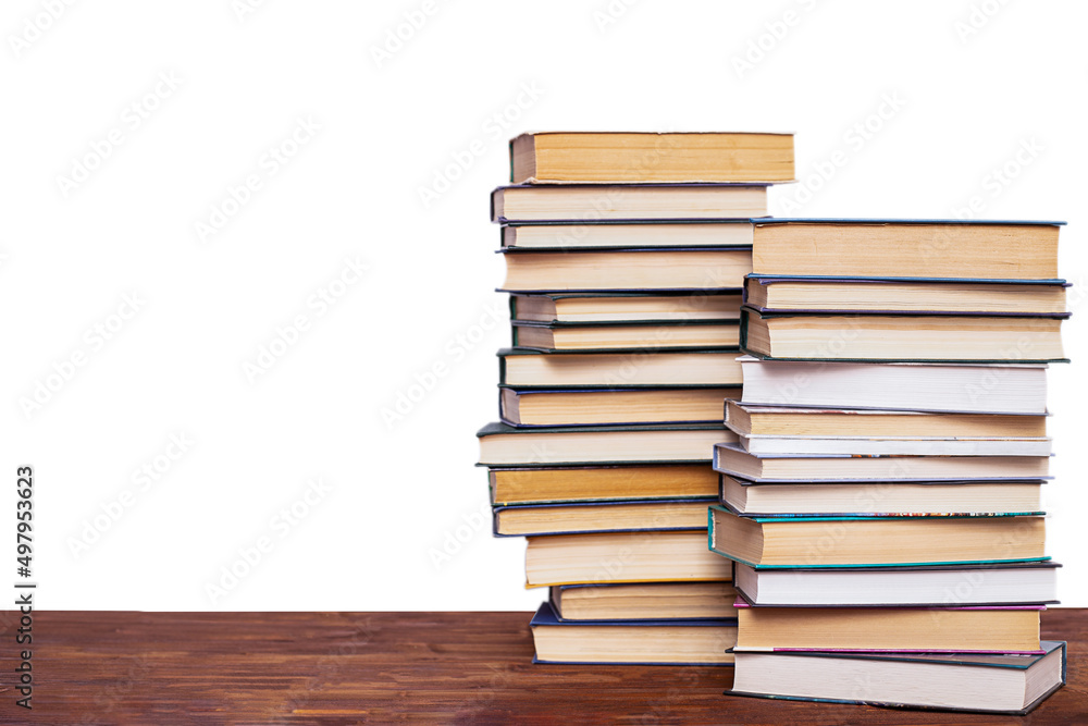 Two stacks of books on a wooden table, isolated on a white background. Two stacks of books on a wooden table, isolated on a white background.