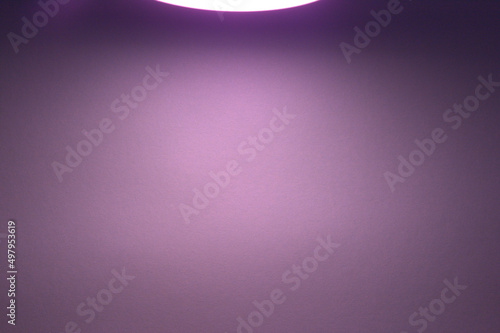Purple background. Light from above. Paper background. Visible lamp.