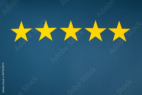 Rating in the form of yellow stars on a blue background. The concept of service quality assessment.